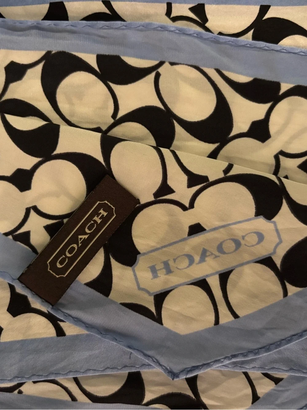Coach scarf features the signature monogram print in black and white with light